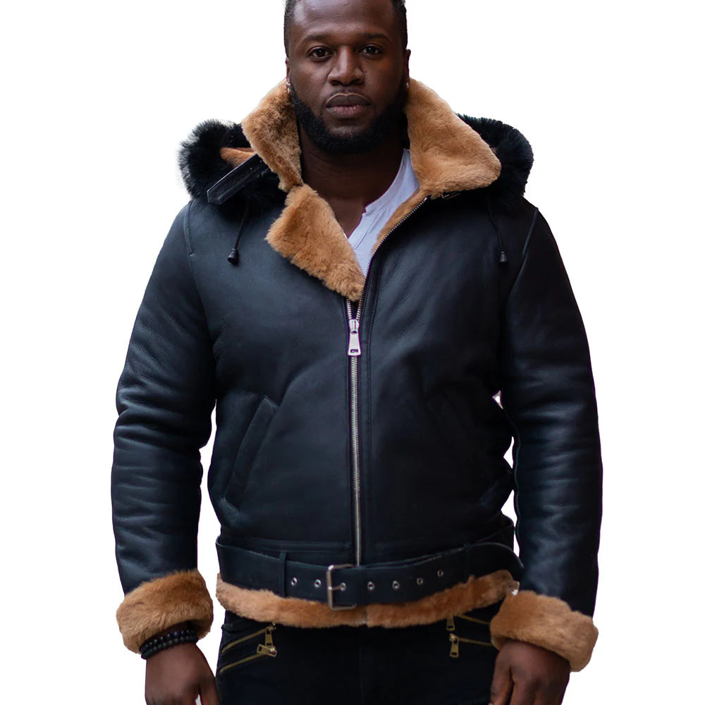 Front view of a man wearing Jean's B3 Bomber Aviator Shearling Jacket with hoodie, featuring sleek black leather with contrasting tan shearling lining around the collar and cuffs. The jacket includes a front zipper closure and leather belt detailing at the waist, perfect for colder weather.