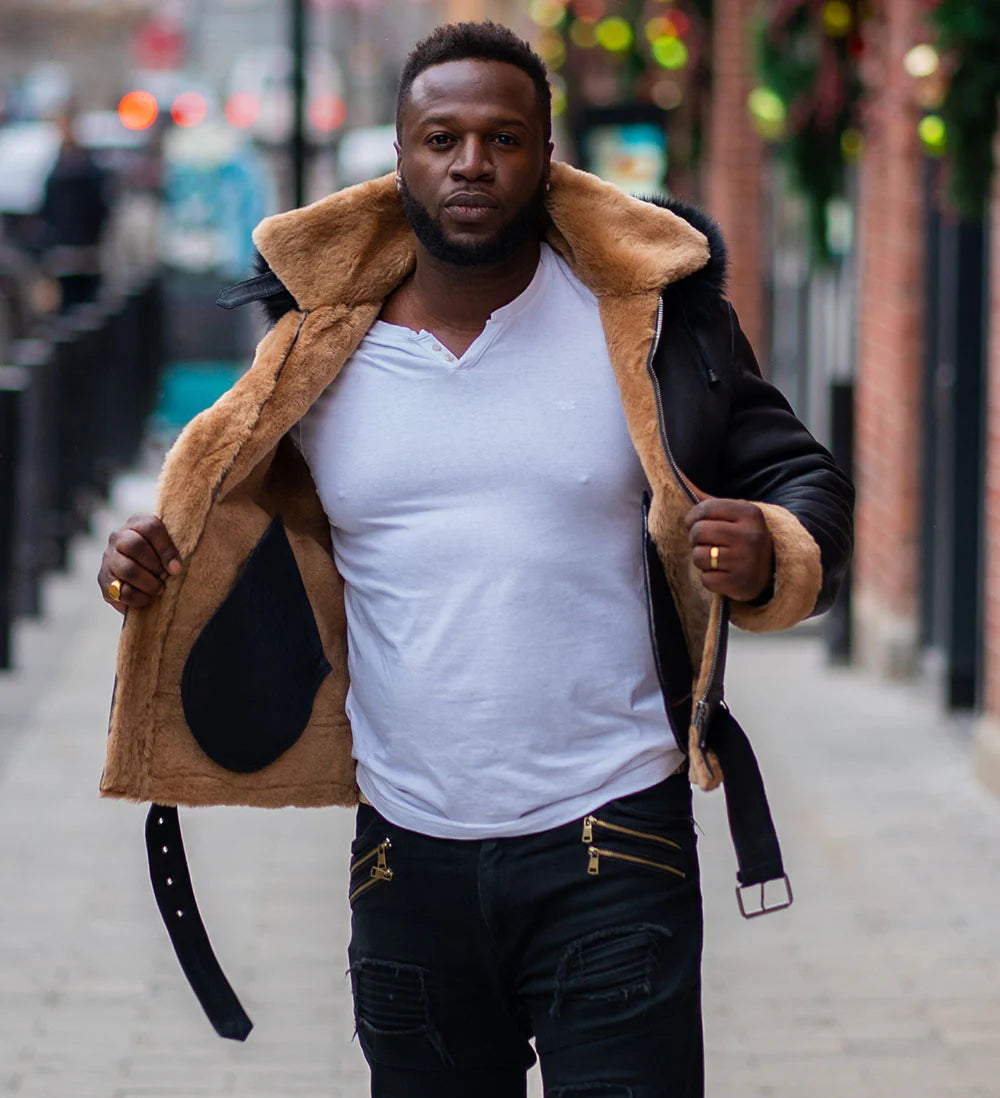 Interior view of Jean's B3 Bomber Aviator Shearling Jacket with hoodie, showing plush tan shearling lining on black leather, worn by a man on a city street.