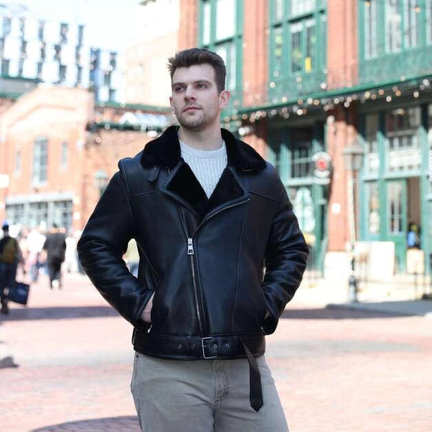 Man in a black leather jacket standing in front of a 'Gooderham & Worts' sign.