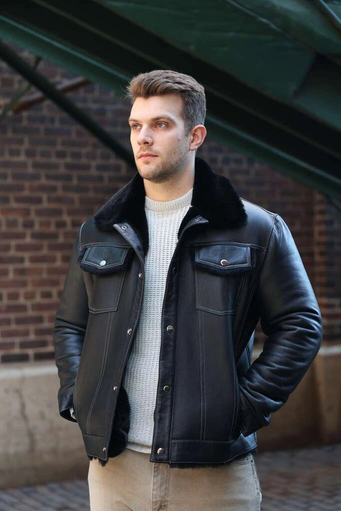 Man wearing a black leather jacket with a brick wall background