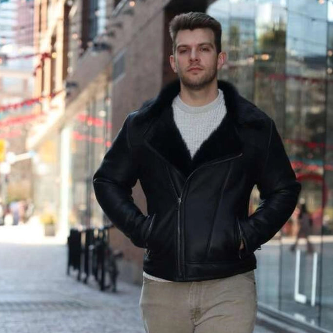 Man wearing a Carter's Toscana Shearling Leather Biker Jacket and beige pants walking on a city street.