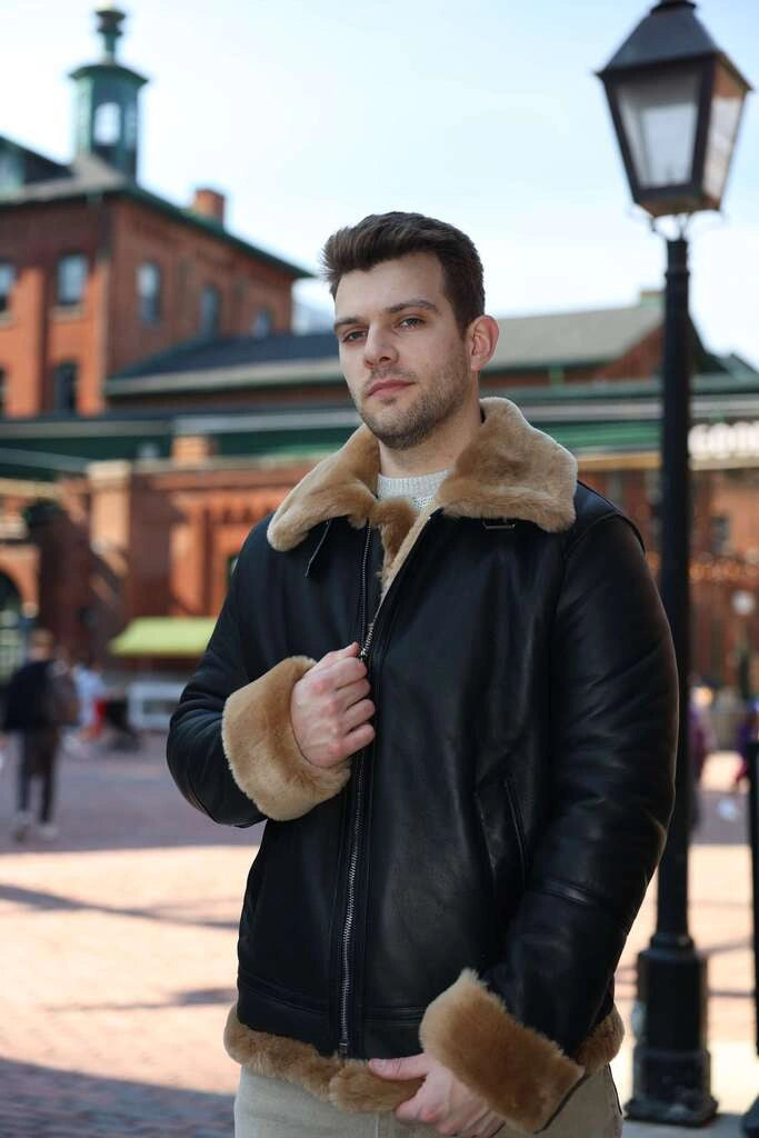 Man wearing Classic Ginger Brown B3 Bomber Aviator Shearling Jacket with fur trim in an urban setting.