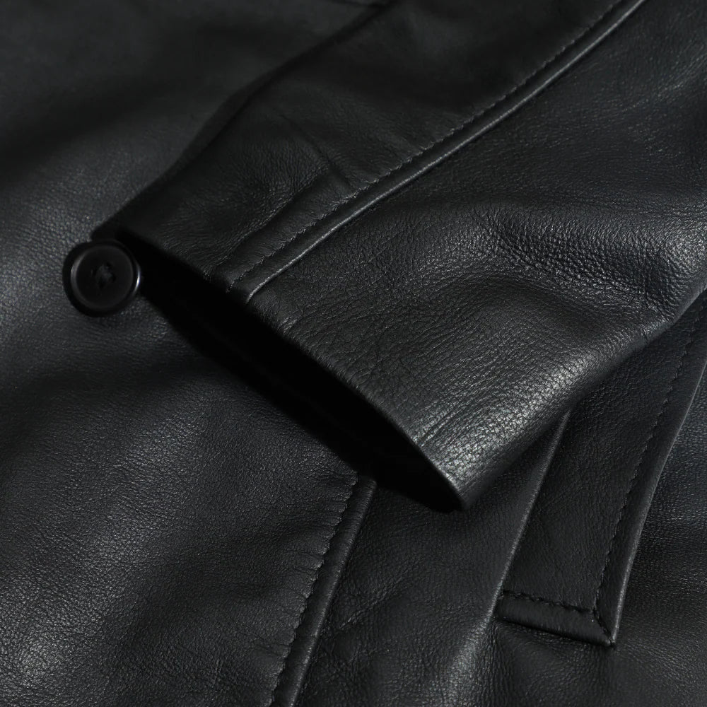Close-up of a black leather coat sleeves with a button