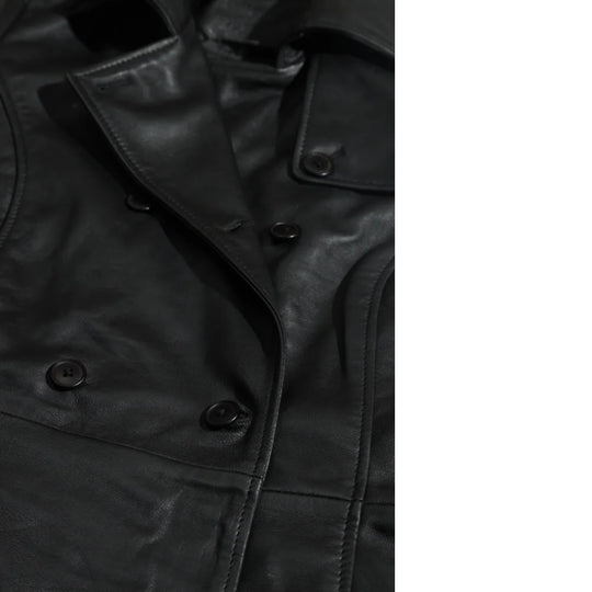 Close-up of a black leather coat with button details and lapels on a white background.