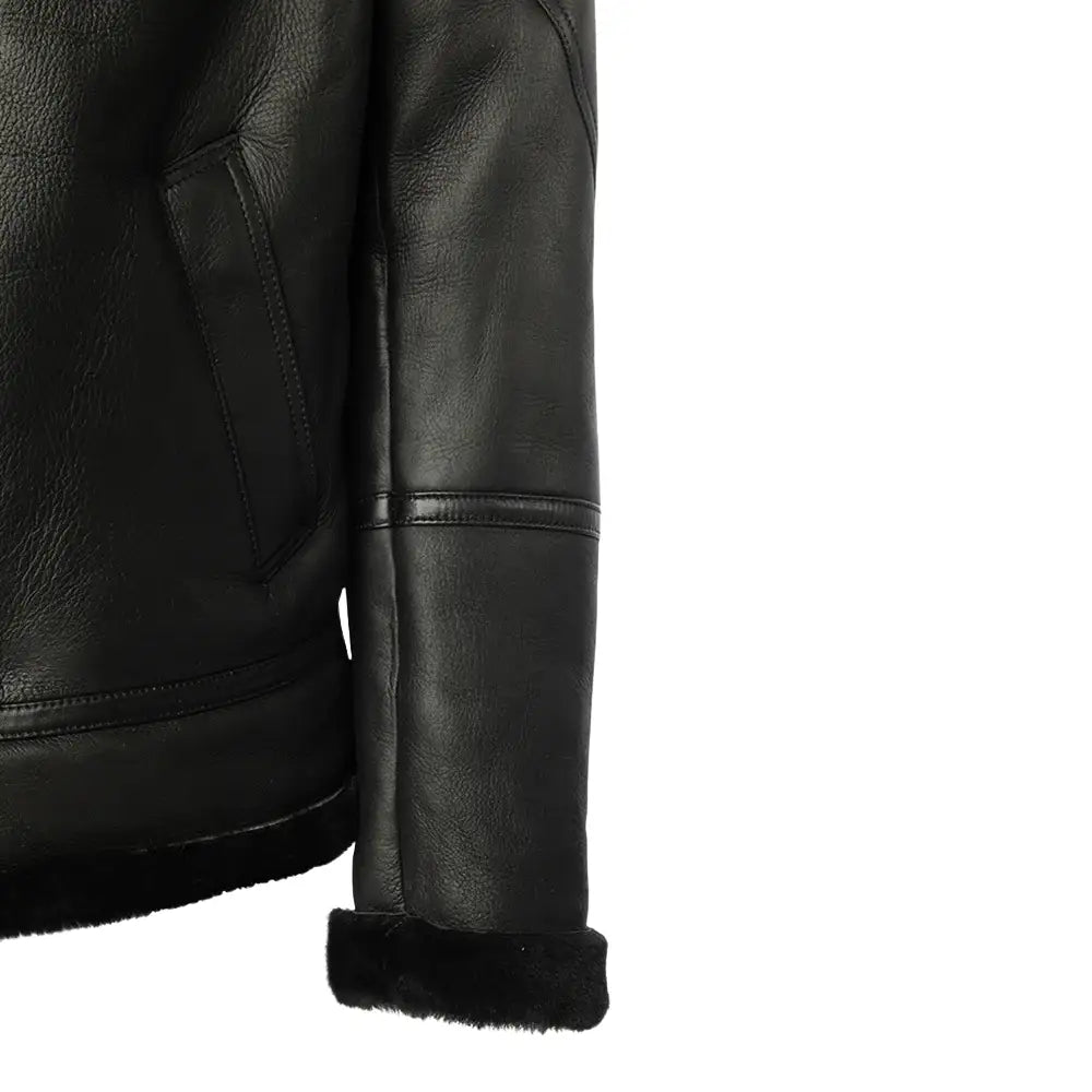 Side profile of the black bomber shearling jacket, highlighting its smooth leather design and ribbed knit cuffs that create a comfortable, snug fit.