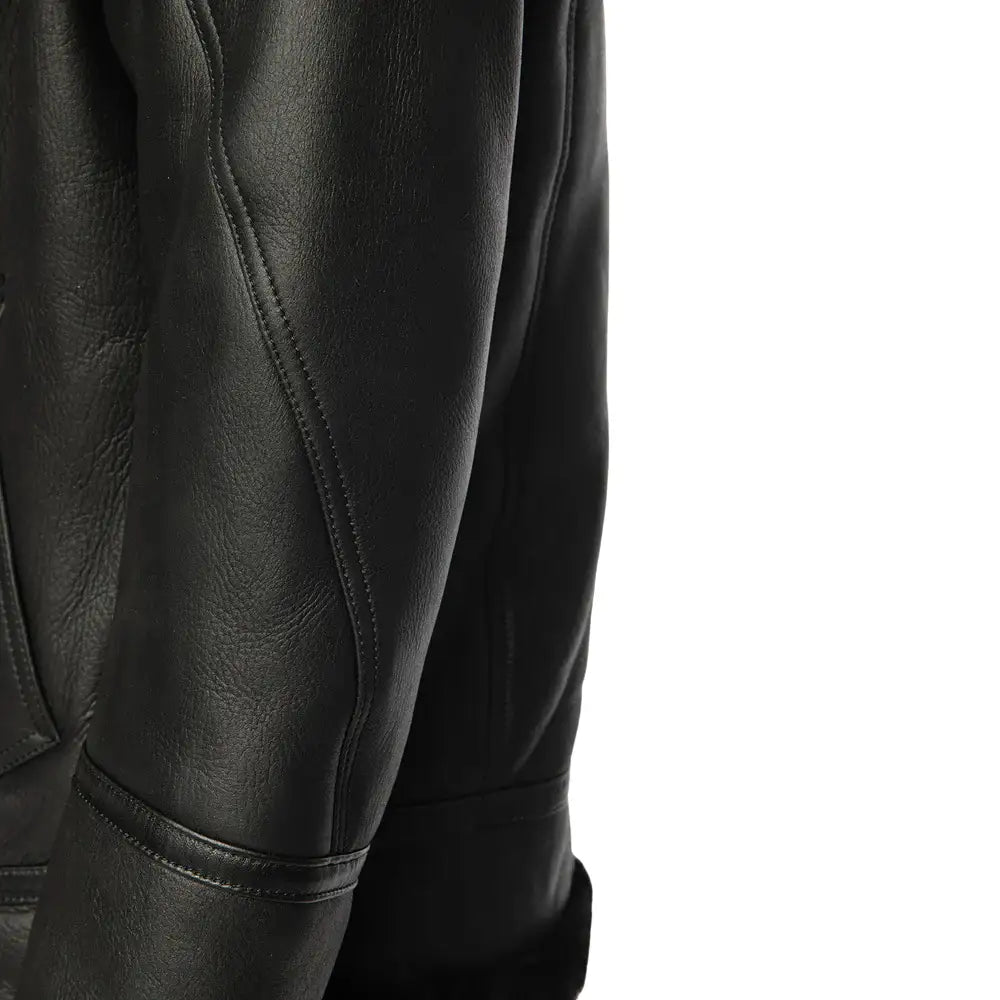 Side profile of a black bomber shearling jacket, highlighting the smooth leather texture and soft fur lining that enhances both warmth and style.