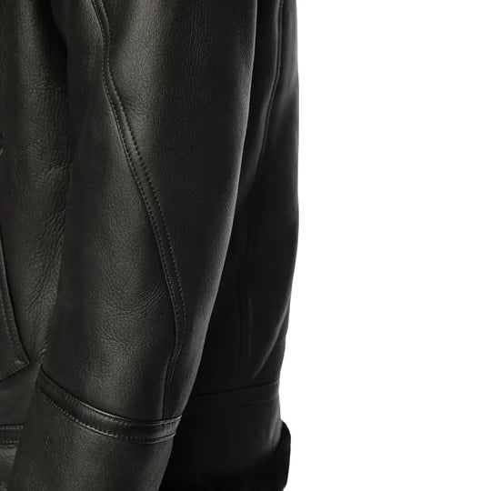Side profile of a black bomber shearling jacket, highlighting the smooth leather texture and soft fur lining that enhances both warmth and style.