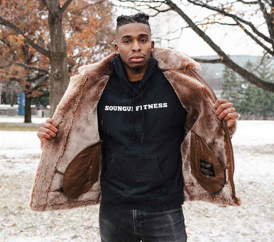 Lifestyle shot of the Felix brown jacket held open to reveal the thick, warm sheepskin fleece lining and internal leather-trimmed pockets.