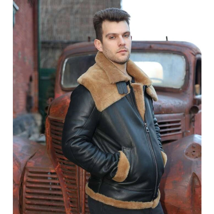 Man wearing Graysen black Aviator bomber shearling jacket with brown fur lining standing in front of an old rusted truck.