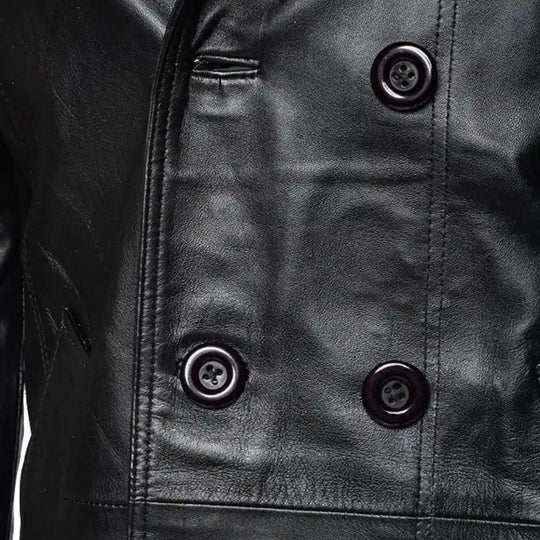 Close-up of a black leather coat with button details.