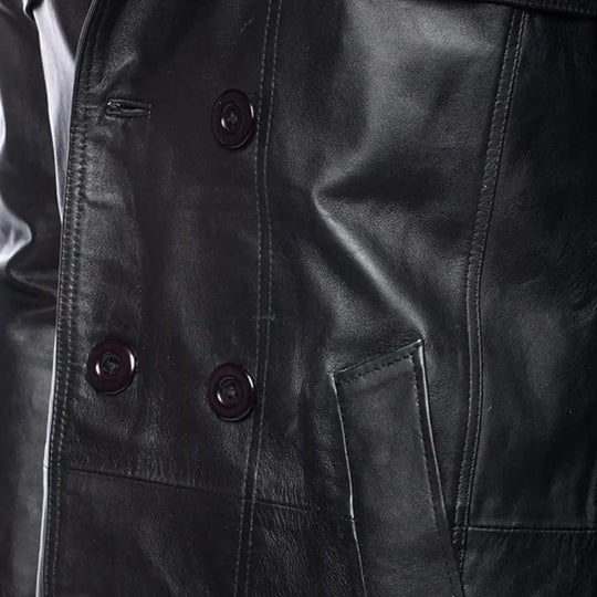 Close-up of a black leather coat with buttons and a pocket.