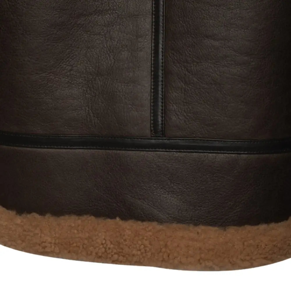 Close-up of the waist adjustment buckle on the Rob Brown B3 Bomber Jacket, designed for a customizable fit. The buckle is paired with tan shearling lining along the jacket’s waist.