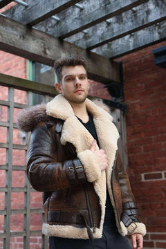 Man wearing Rocco vintage brown aviator shearling jacket with fur lining against a brick wall.