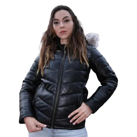 A model wearing the Snow’s hooded leather puffer in a winter setting, demonstrating the jacket’s warmth, volume, and protective fit.