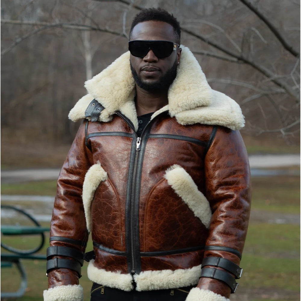 Man wearing a Terry Gretzky Vintage Oxblood bomber jacket with double collar with black glasses white fur lining in an outdoor setting.