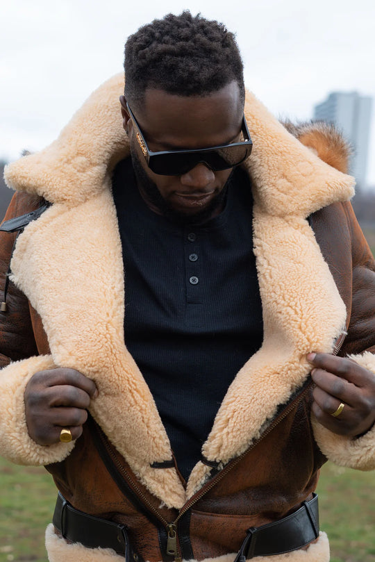 Lifestyle photoshoot of a man wearing Rocco vintage shearling jacket with an open zipper showcasing interior of shearling jacket.